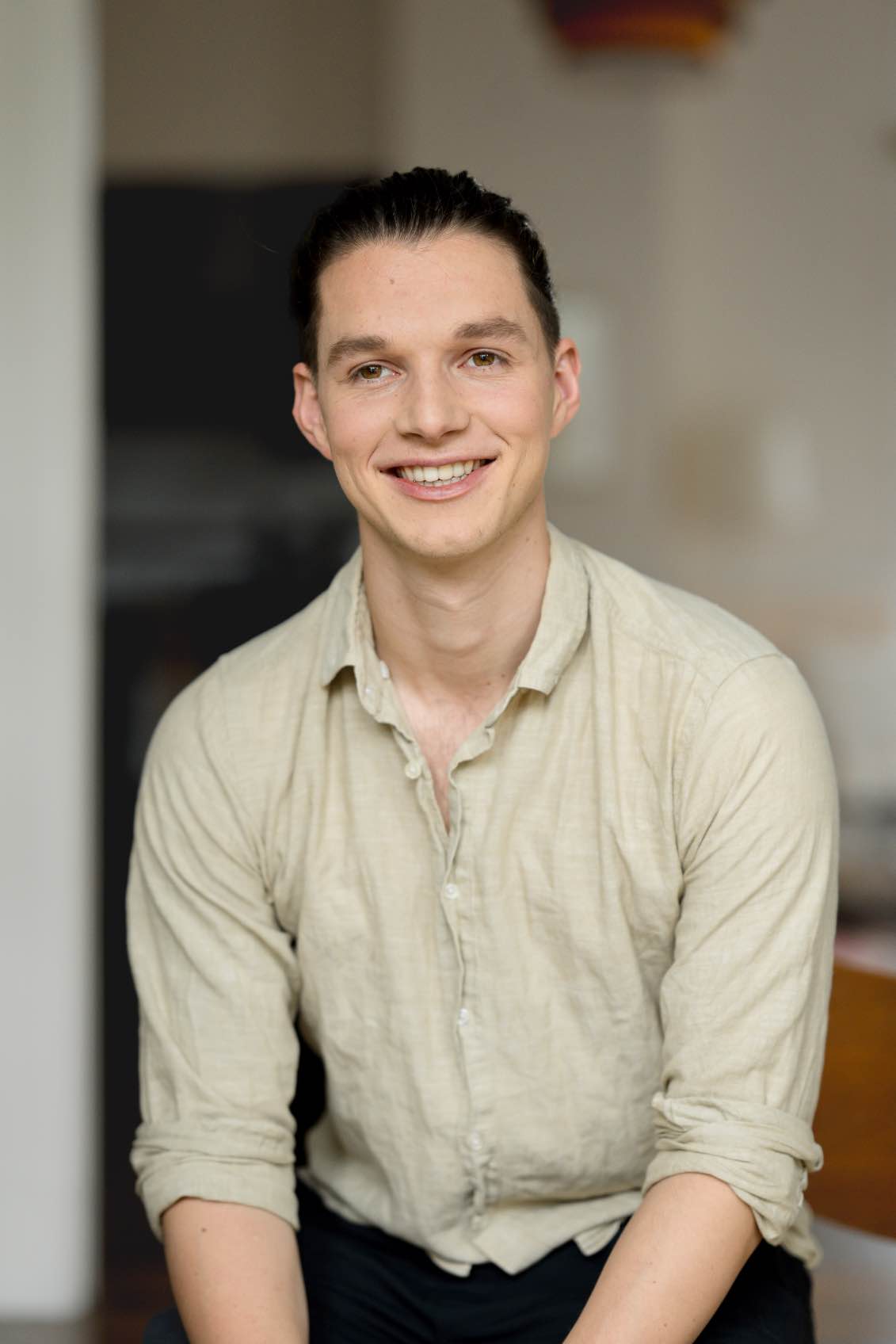 Smiling person seated indoors — founder of Seven Life Areas, offering guidance for living with clarity, harmony, and purpose.