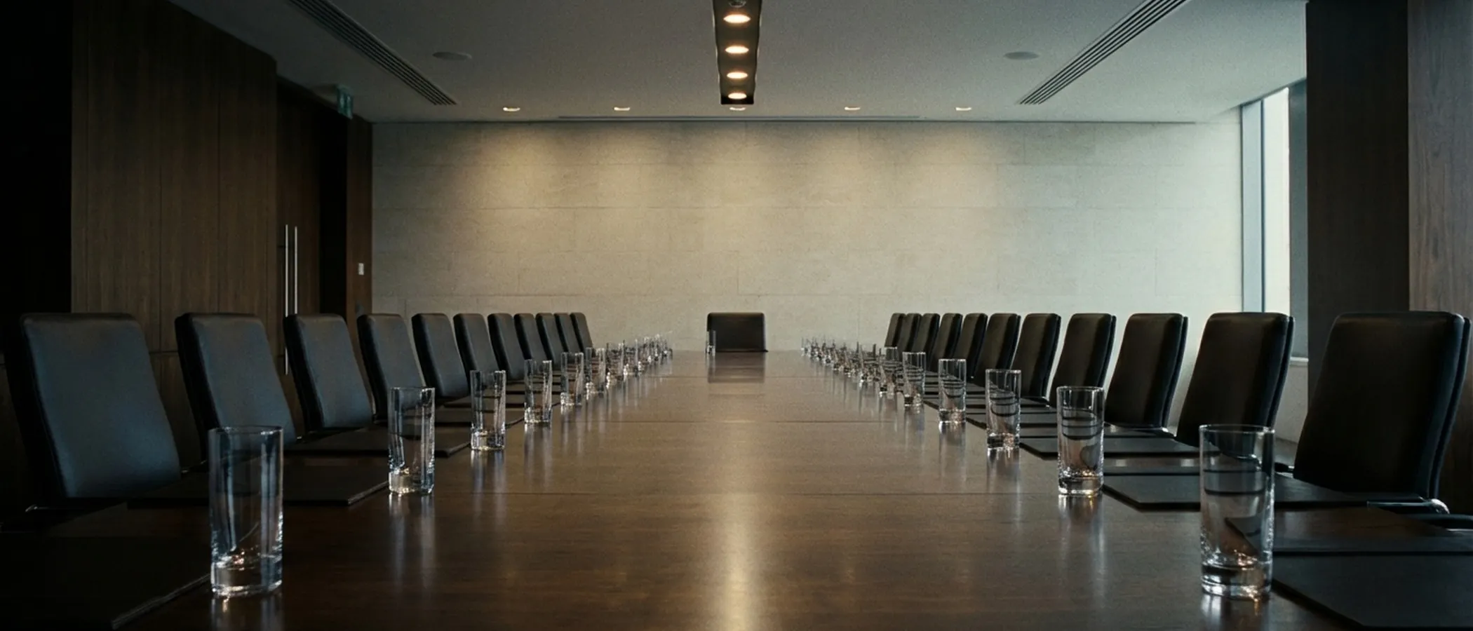 Empty boardroom with many chairs and glasses.