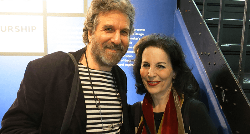 A photo of two people in an exhibition room, near some stairs.