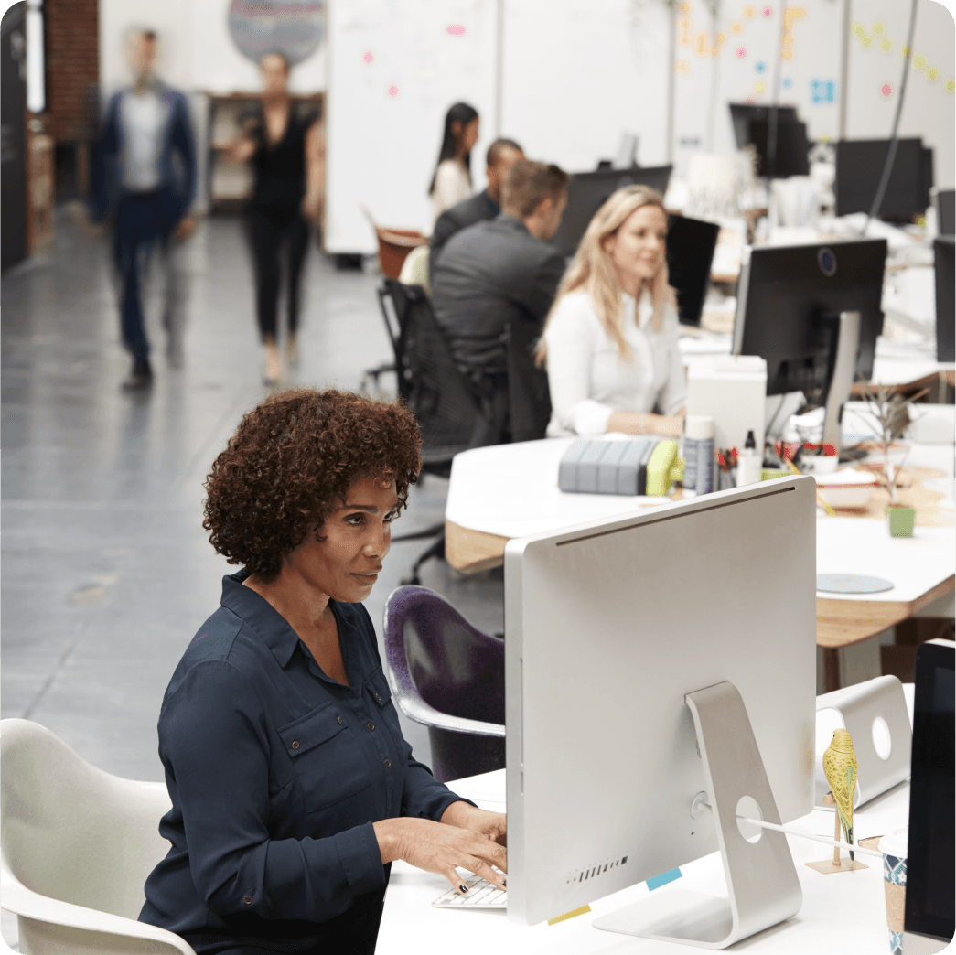 A woman employee showing something to her coworker on laptop