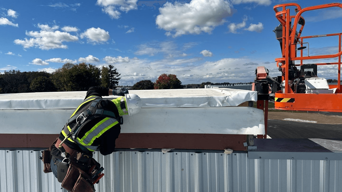 a man working on a roof with a power drill