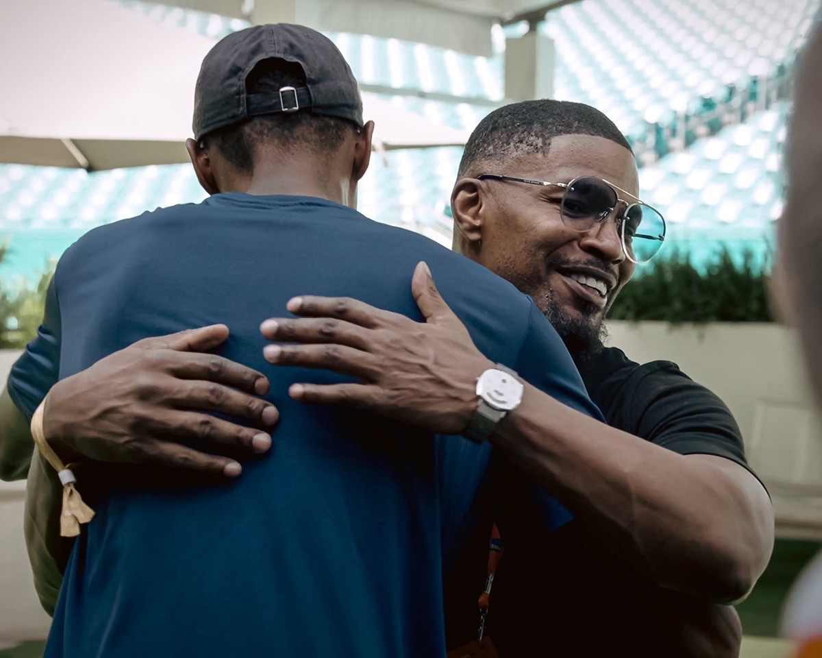 A photo of Jamie Fox hugging a friend at the Miami Open.