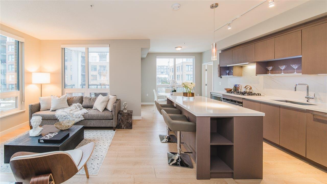 Modern, open-concept apartment interior featuring a living area and kitchen with natural light and sleek furniture.