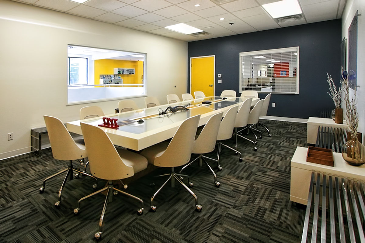 Conference room with a white table and chairs, designed for collaborative meetings.