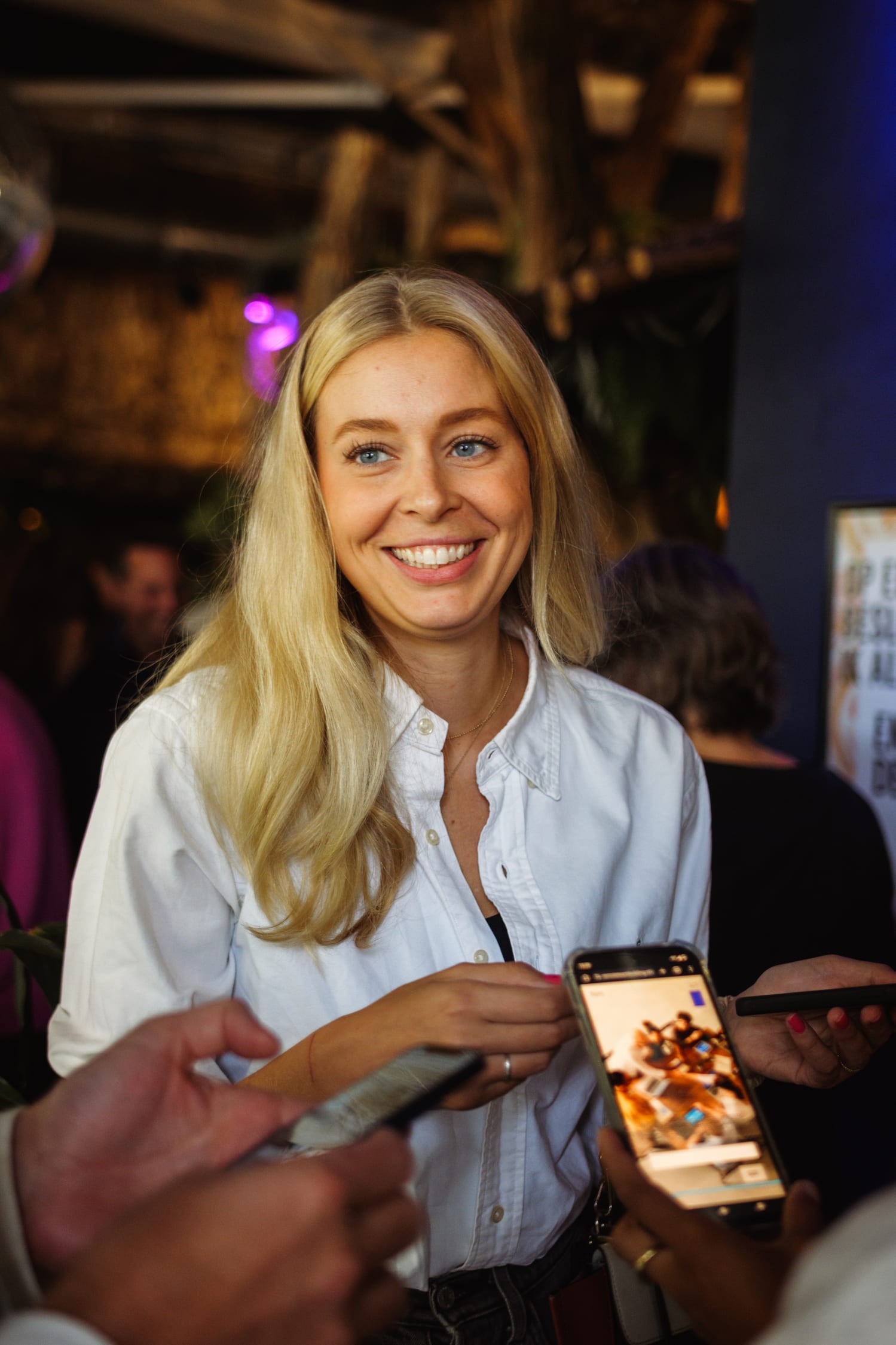 Deelnemer aan een Ice Breaker activiteit van The Box Company lacht terwijl ze in gesprek is met collega’s.