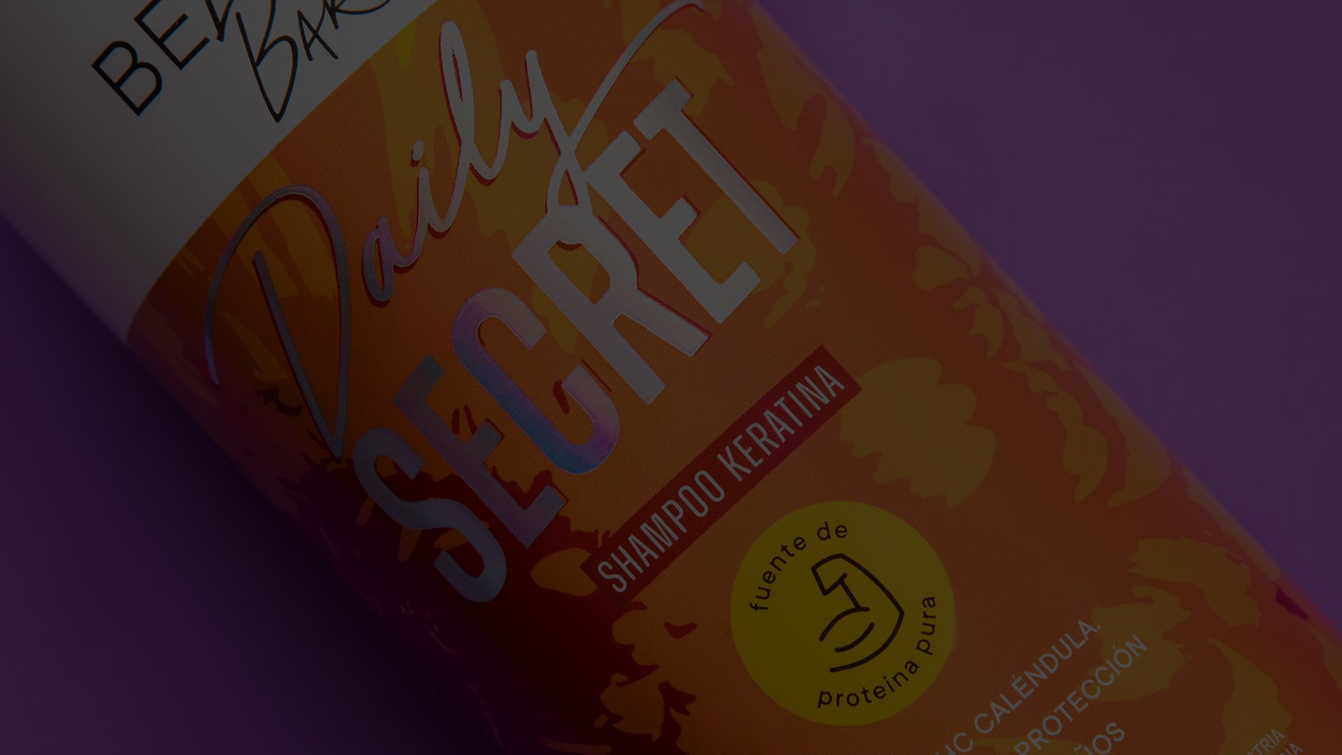 A vibrant shampoo bottle labeled "Daily Secret Shampoo Keratina" with orange and yellow floral designs, suggesting hair care focus, on a purple background.