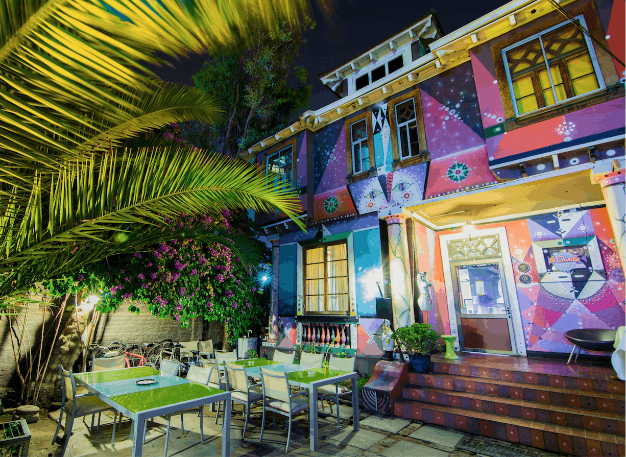 A colourful painted building and a patio outside at night