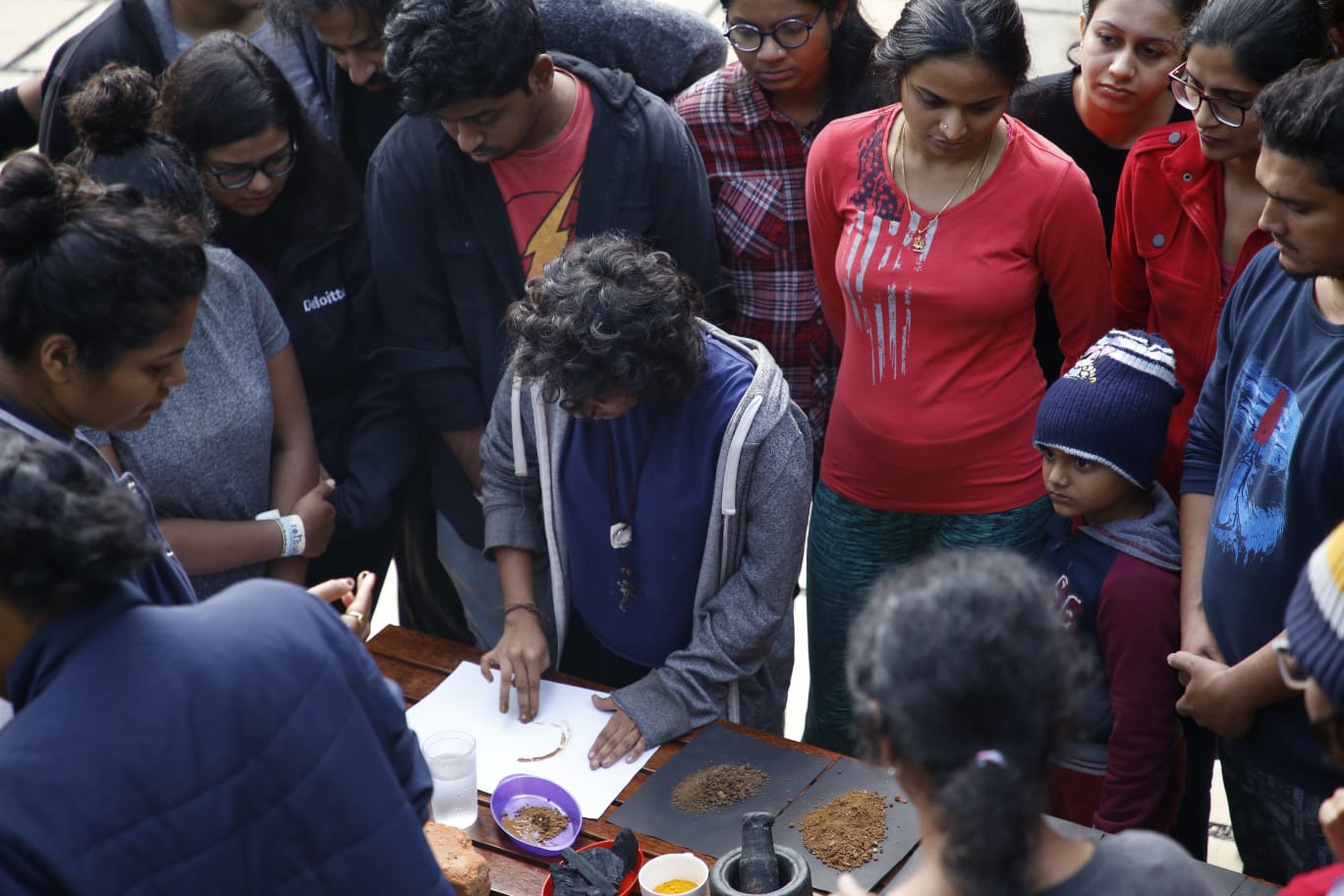 man in gray hoodie and blue denim jeans standing on brown wooden parquet flooring