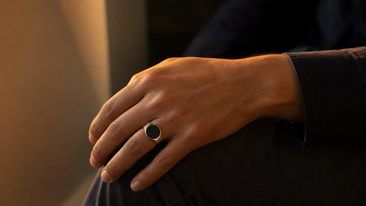 Hand resting after dhikr with a dark unlit smart tasbih ring in warm evening light