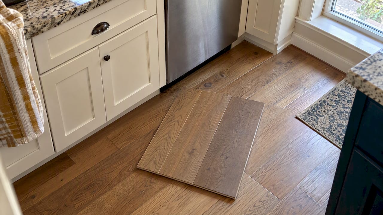 Hardwood sample checked beside kitchen cabinets
