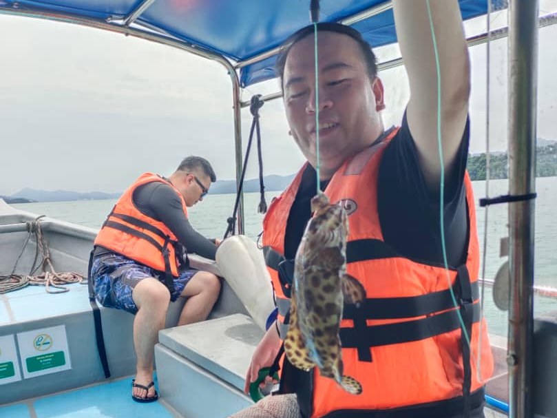 A guest with his catch on the fun fishing boat