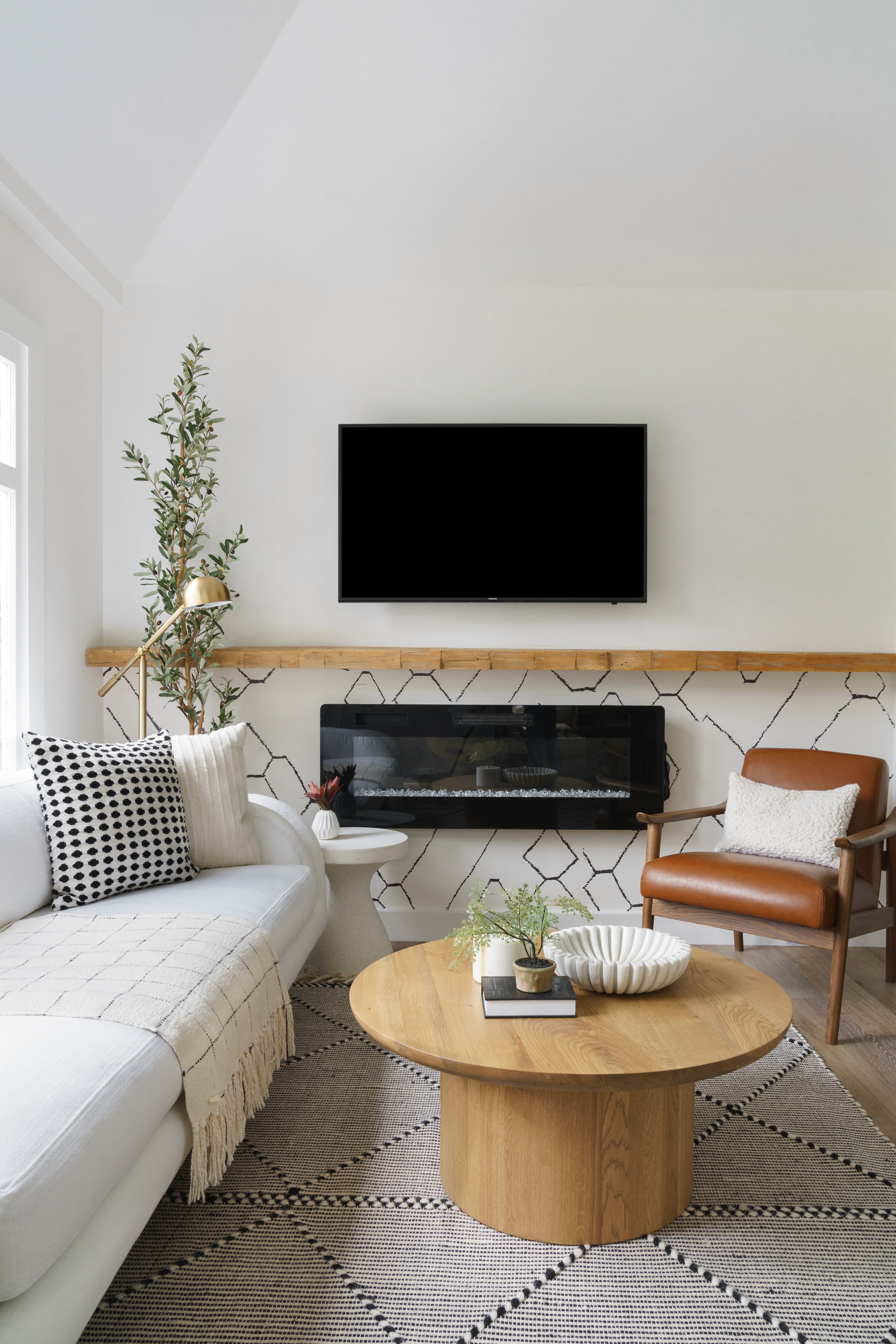 This contemporary living room features a cozy, airy atmosphere with a custom linen sofa and earthy wooden accents