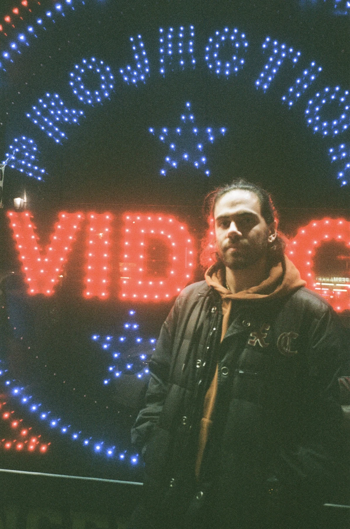Yunes Calore in a night portrait beneath colourful cinema lights