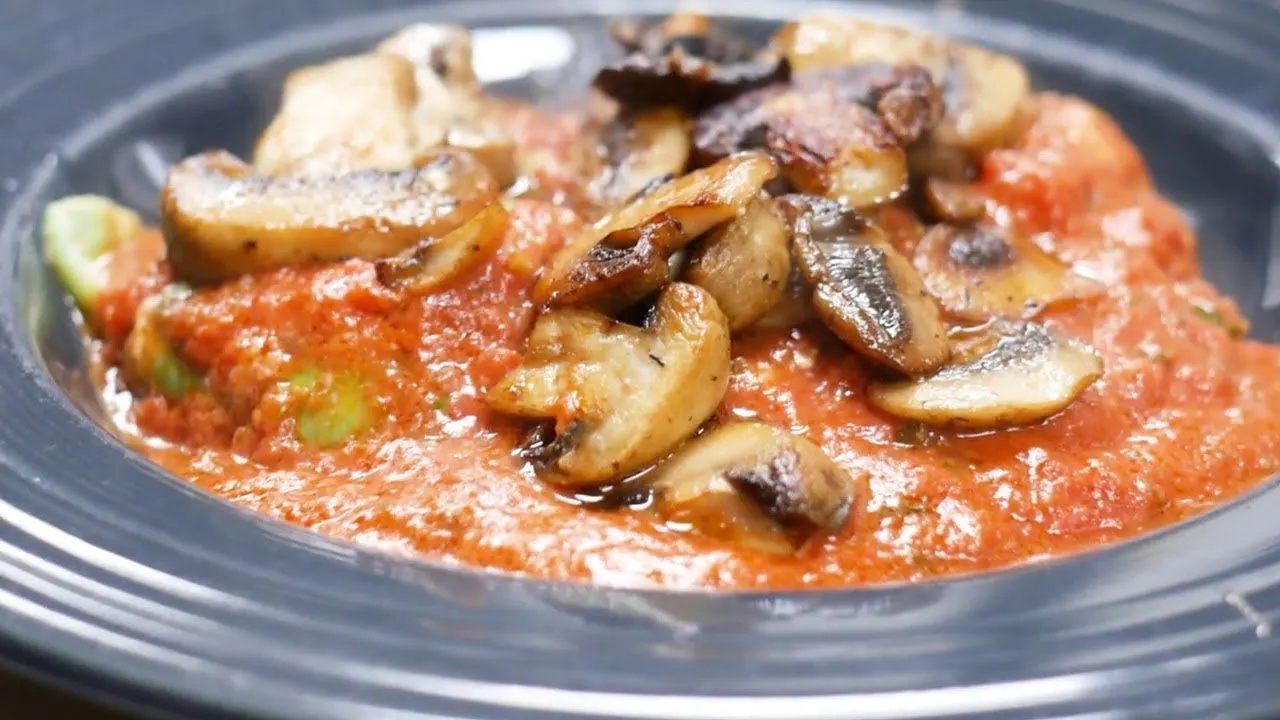 Pasta in tomato sauce topped with sauteed mushrooms