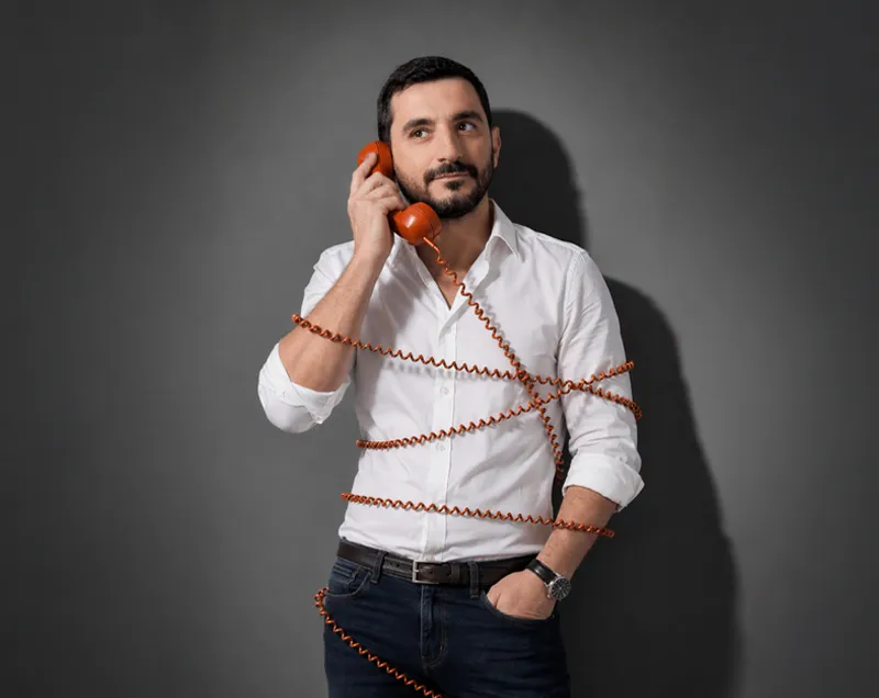 A close-up of a pink cocktail in a martini glass, set against a nighttime background with soft, blurred colors.