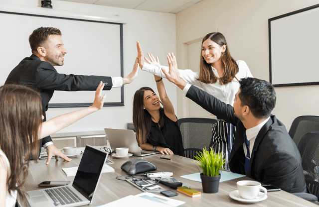 Two colleagues discussing data on a laptop screen.