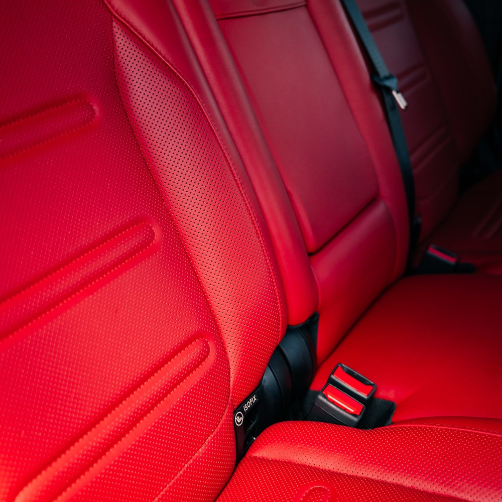 Close-up of the red leather interior stitching and premium door panel details in a Mercedes-Benz G 550.