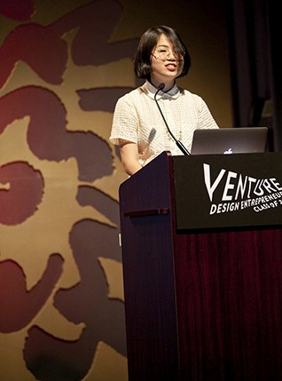 portrait of a student dressed in white giving a speech