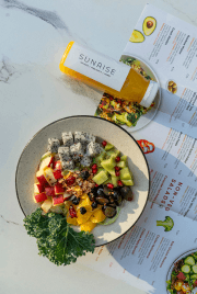 Sunrise Juice Bottle and Salad Bowl with Menu in Background