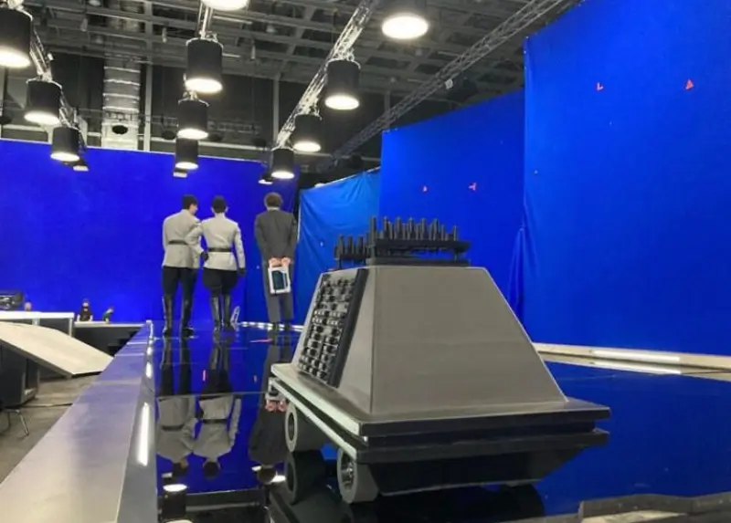 A floor level shot of a Mouse Droid in front of blue screen