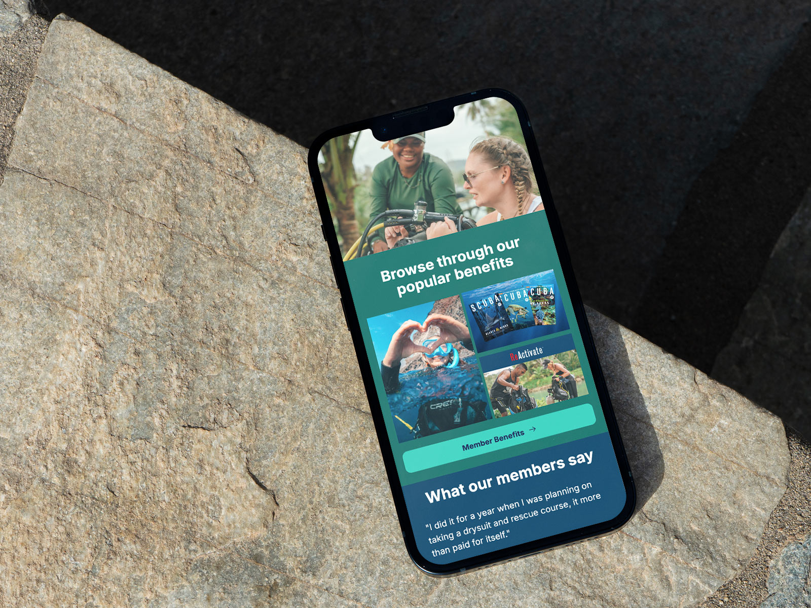 Smartphone mockup resting on textured stone surfaces displaying a PADI Club membership email featuring lifestyle imagery, benefit highlights, testimonial content, and a mobile-first modular email design system.