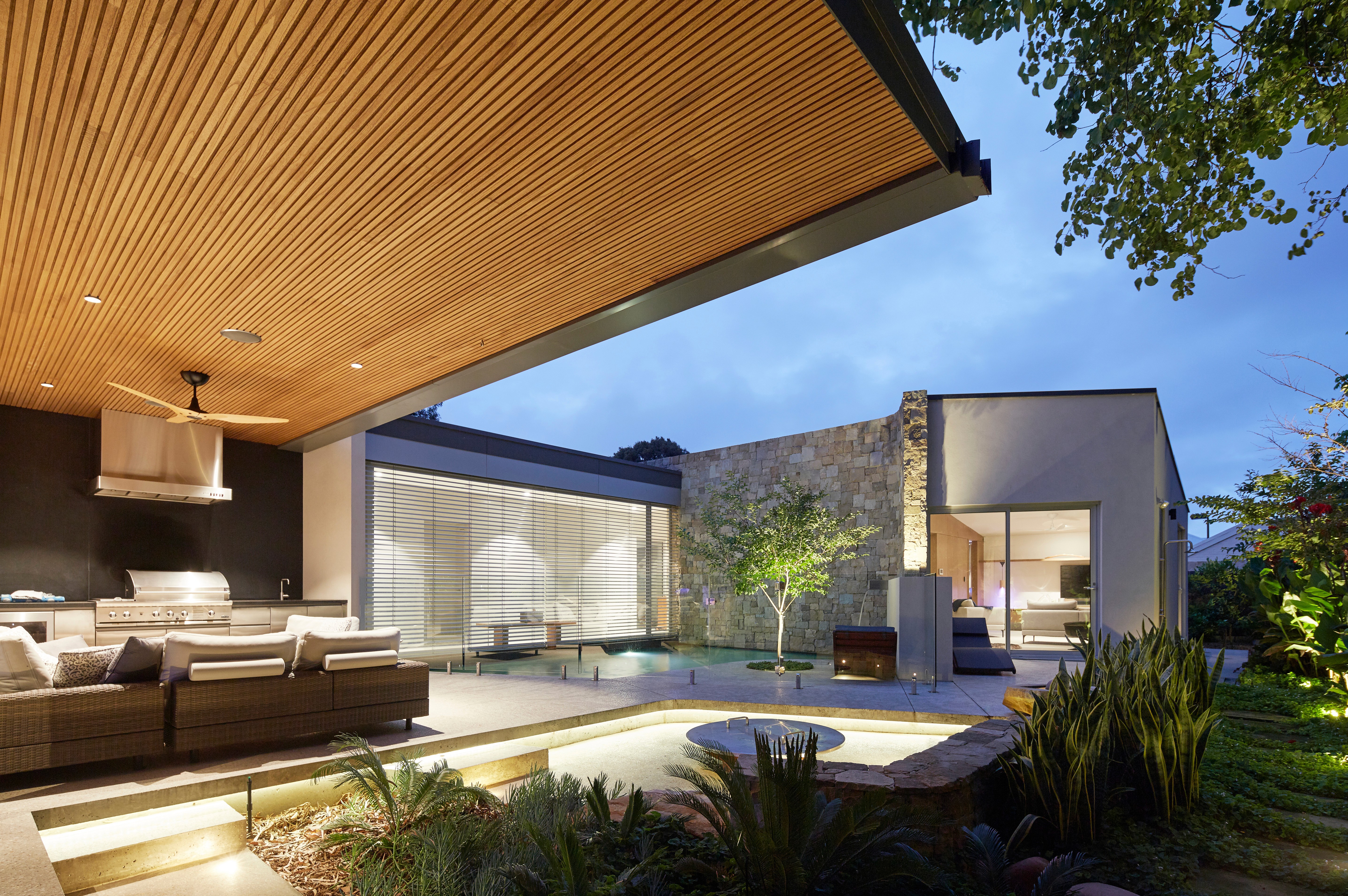 Modern living room with vertical garden, yellow sofas, and stylish coffee tables.