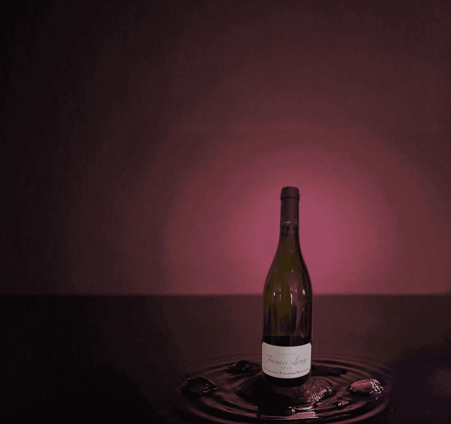 Photo de la bouteille "Clos des Vignes Rondes" du domaine François Lumpp sur fond rouge bordeaux