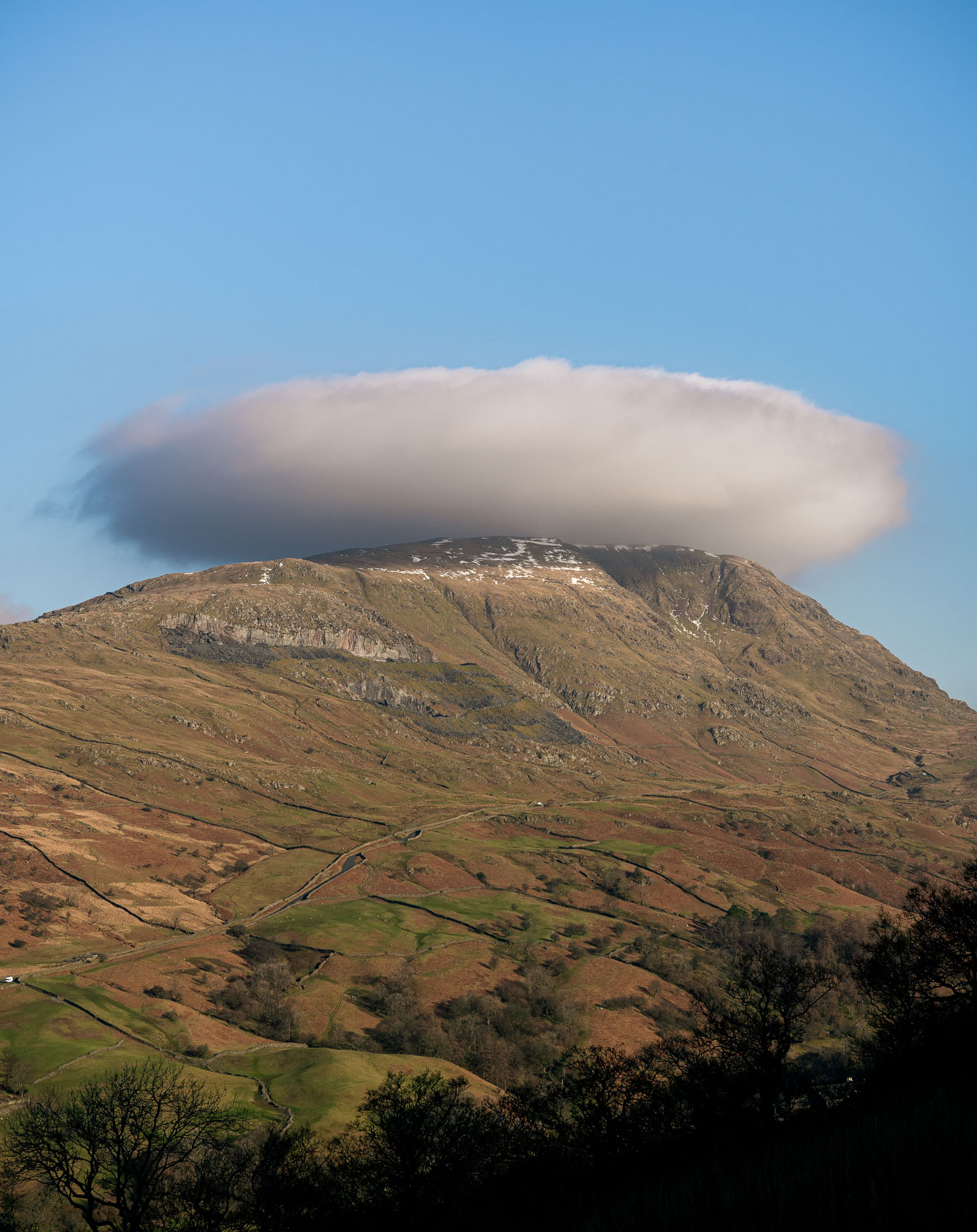 A single, circular cloud above Red Screes. The tip of the fell just hidden slightly – like it's wearing the cloud as a hat.