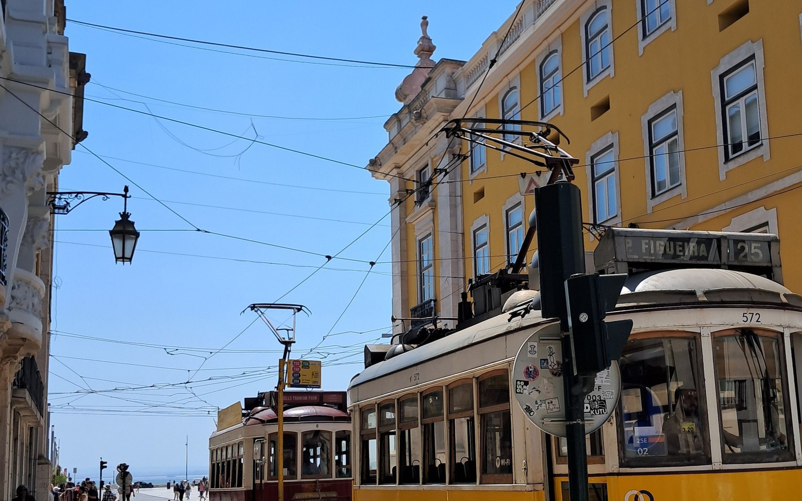 Classic Lisbon trams on a sunny city street
