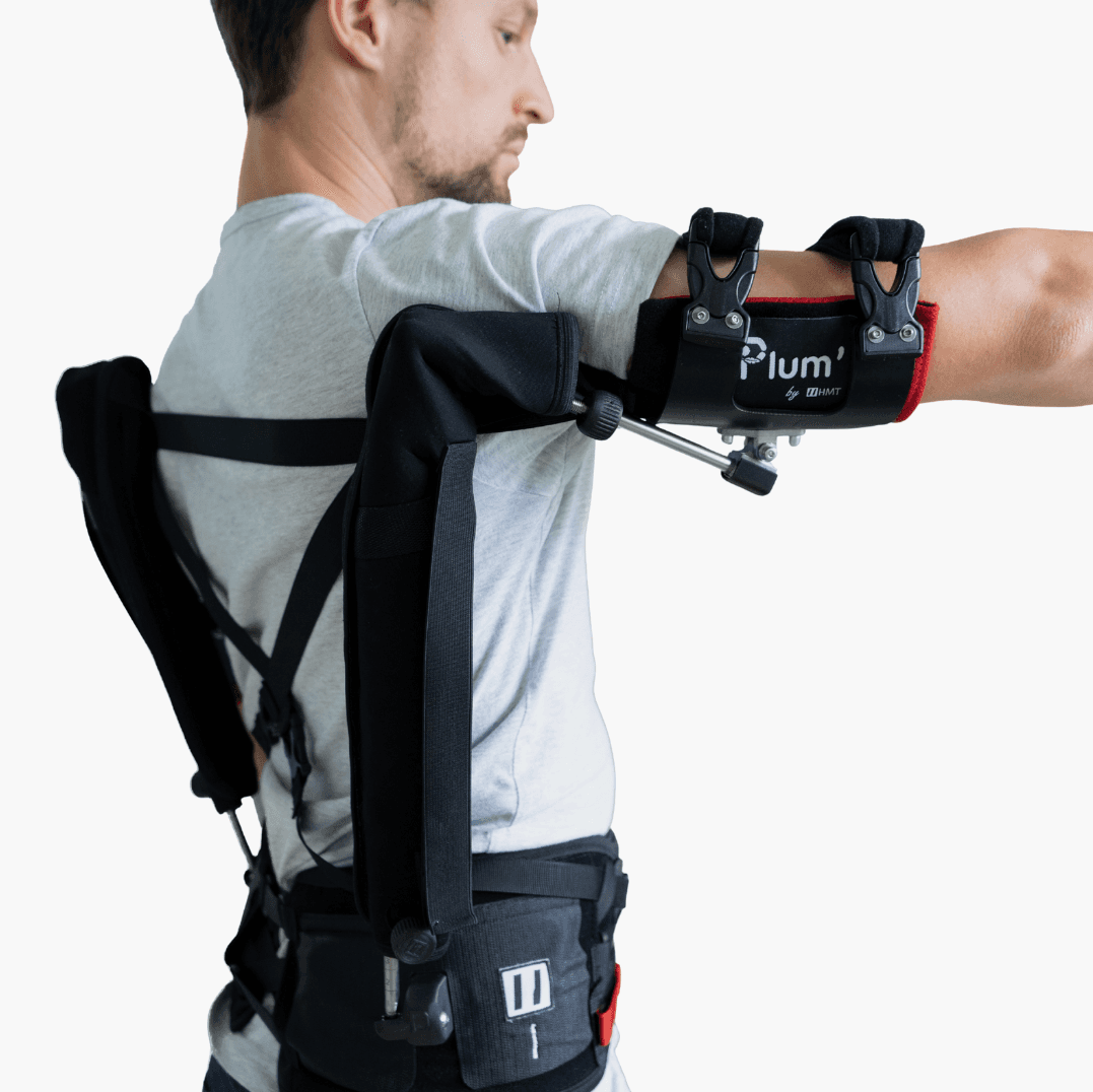 Travailleur portant l’exosquelette Plum’ pour soutenir les épaules, bras tendu à l’horizontale afin de réduire la fatigue musculaire.