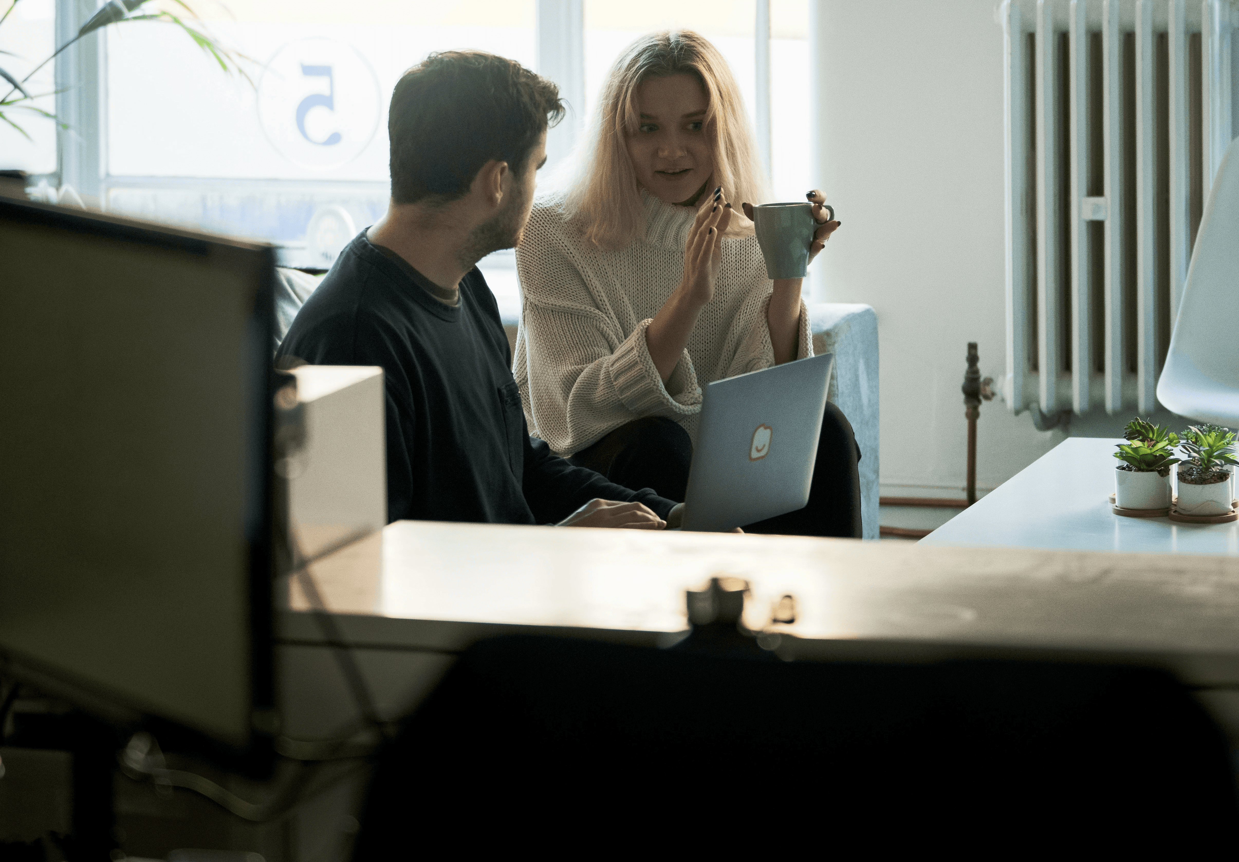 Poignée de main entre deux personnes assises à un bureau avec ordinateur portable et dossier