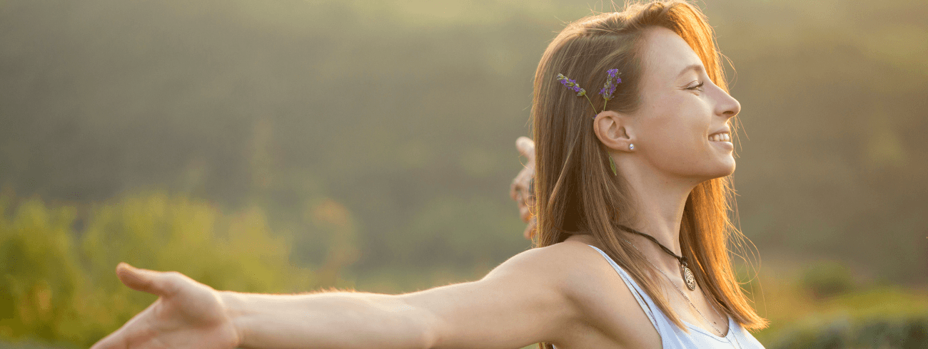 Mulher feliz olhando para o horizonte.