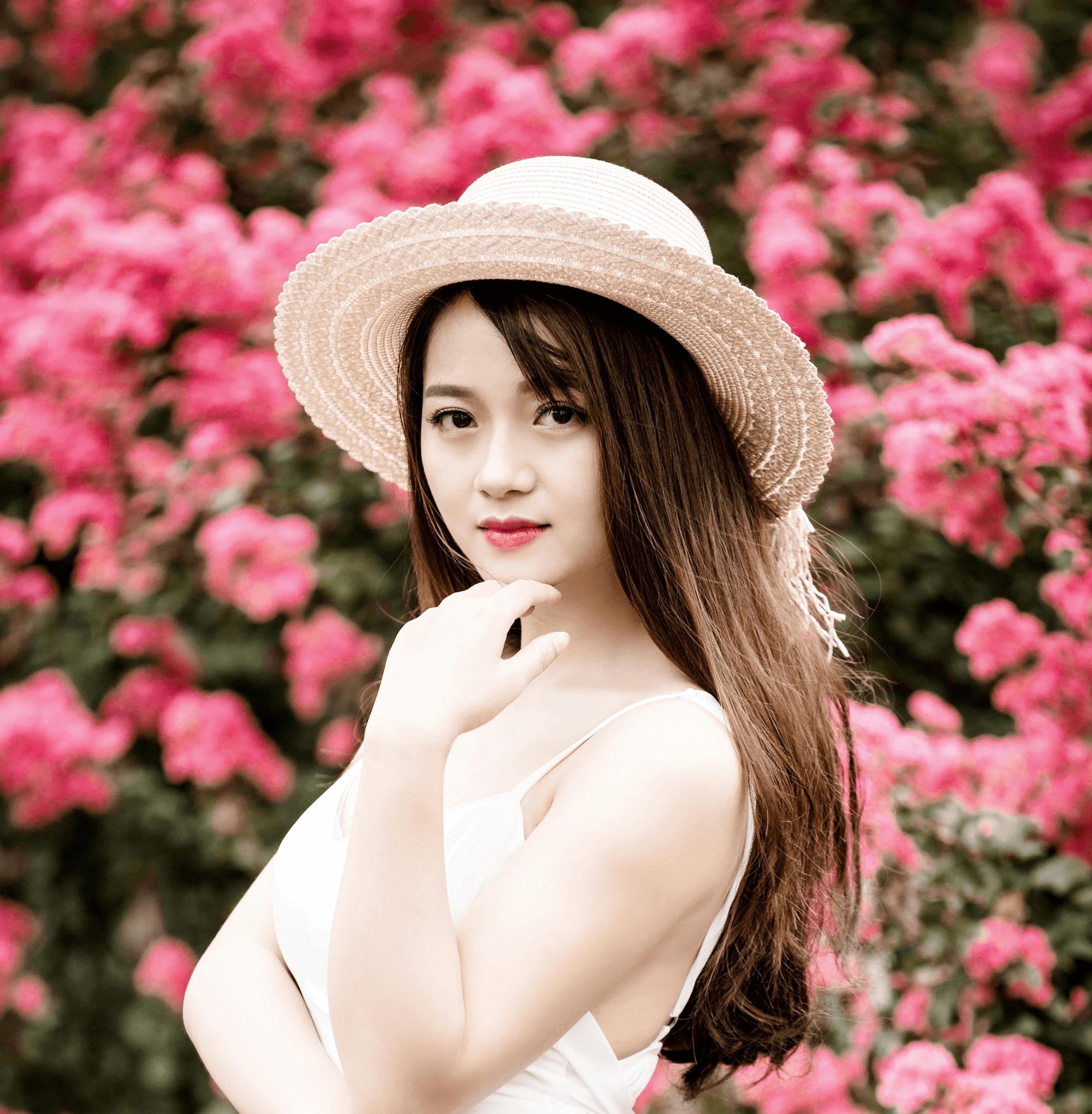 woman wearing dress standing beside pink flowers