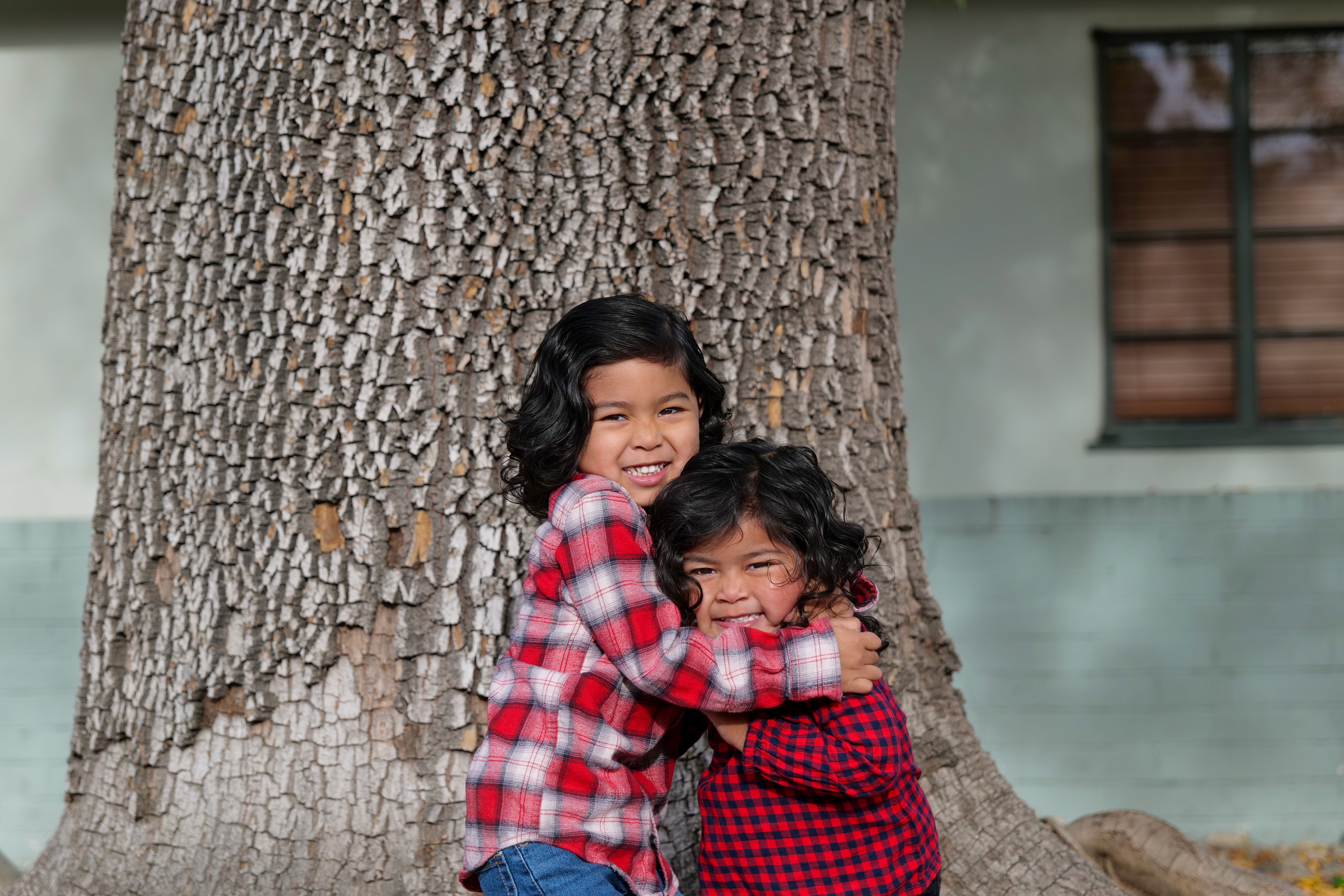 Colorful family portrait of a woman with two kids smiling on front porch in Claremont, CA. | FFotos