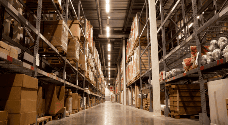 Warehouse aisle with stocked shelves, representing supply chain efficiency and risk reduction