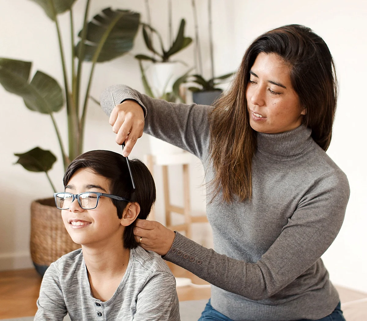 A school aged boy getting head lice removal treatment.