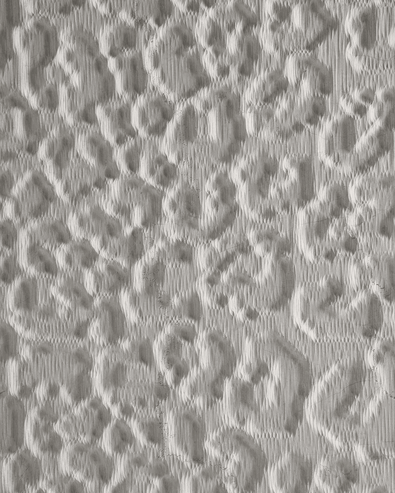 Carved marble surface study inspired by the irregular spotted rhythm of leopard skin, translated into an abstract tactile relief.