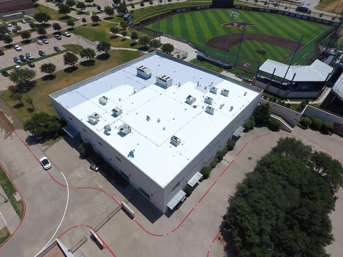 arrington roofing dallas commercial roofing contractors applying roof coating to restore a commercial roof in plano texas