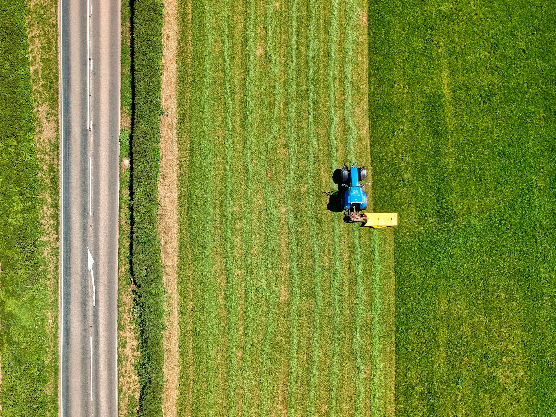 A bird's-eye view of a tractor farming in a rual location in the UK.