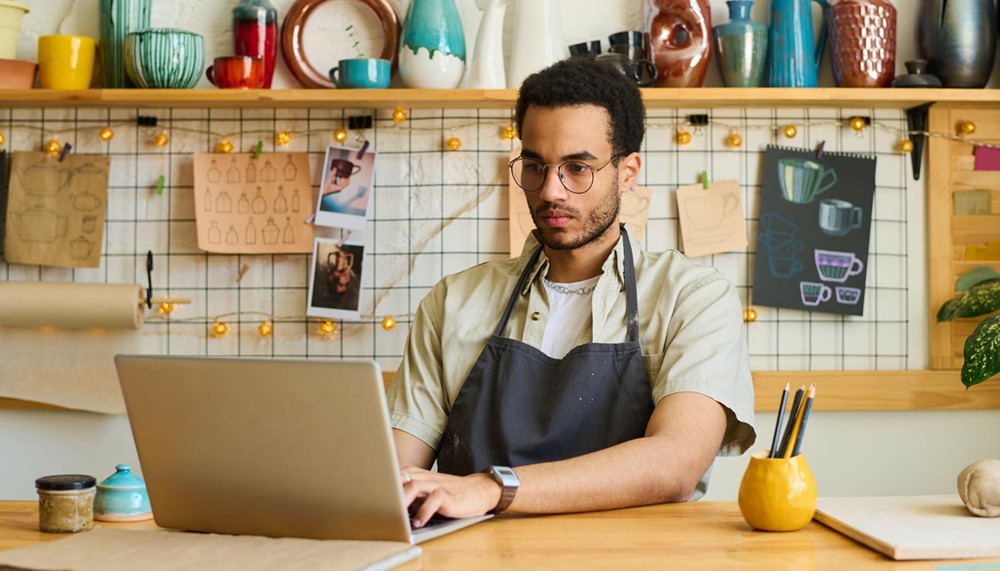 young serious man workwear sitting by workplace front laptop