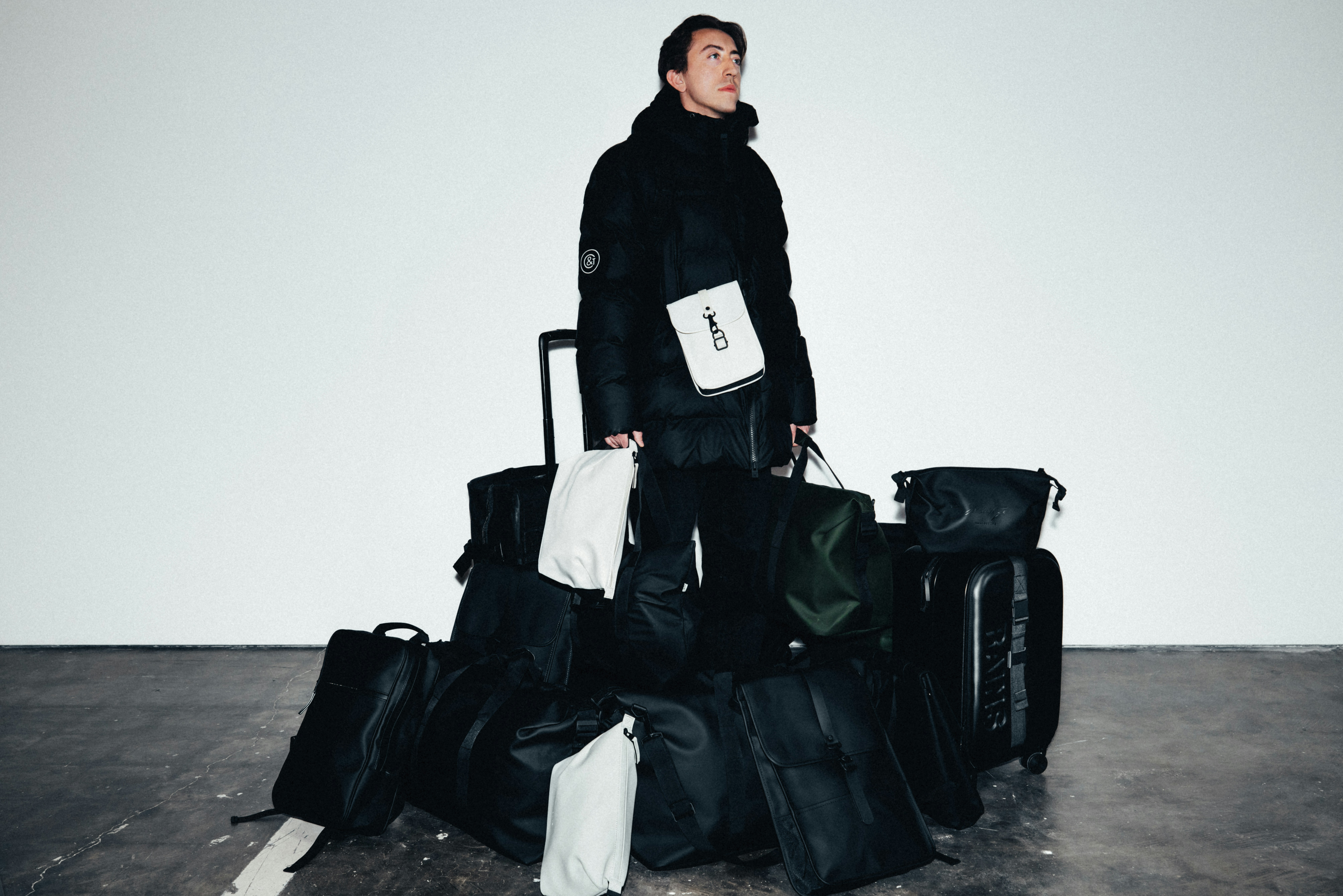 Man in winter coat surrounded by luggage