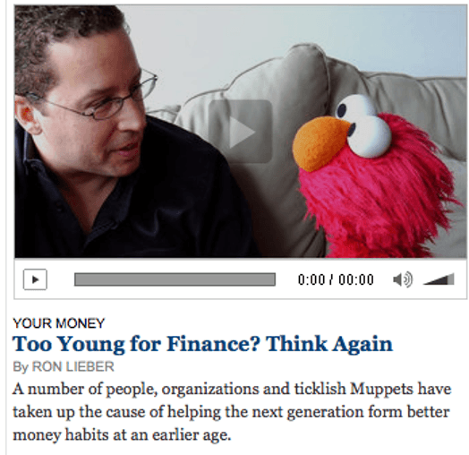 A still shot image of a man and a red poppet with orange nose and ball like eyes.