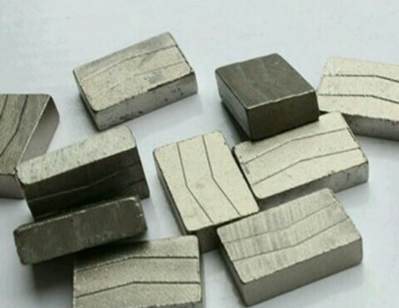 A collection of rectangular diamond segments with visible layers on the surface, used for cutting hard materials like stone and concrete. These segments are designed for industrial cutting tools.