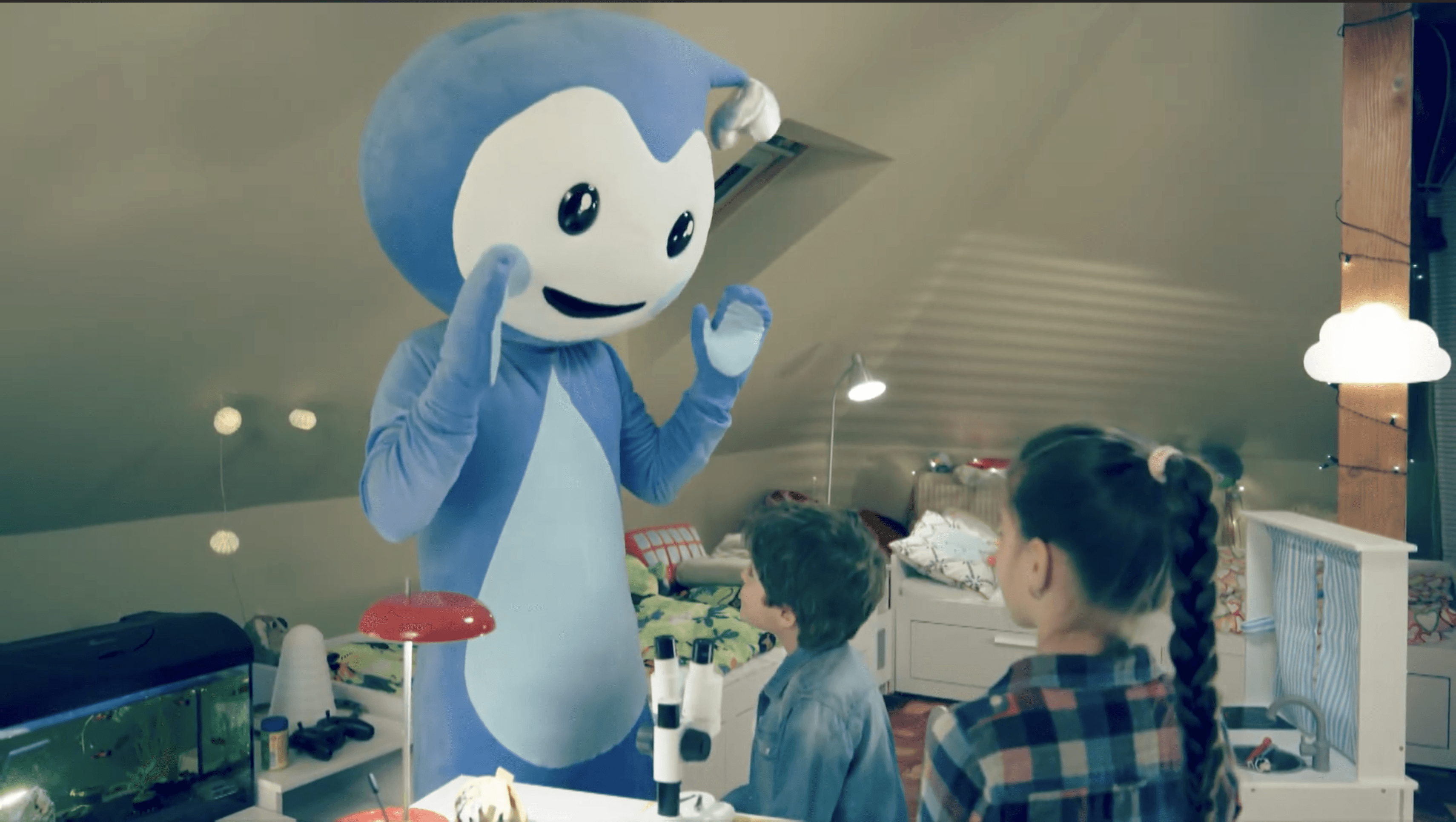 Cseppbarát kék kabalafigurája esti fényeknél tanítja a gyerekeket