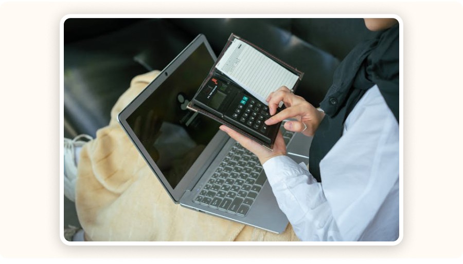 Woman using a calculator and laptop