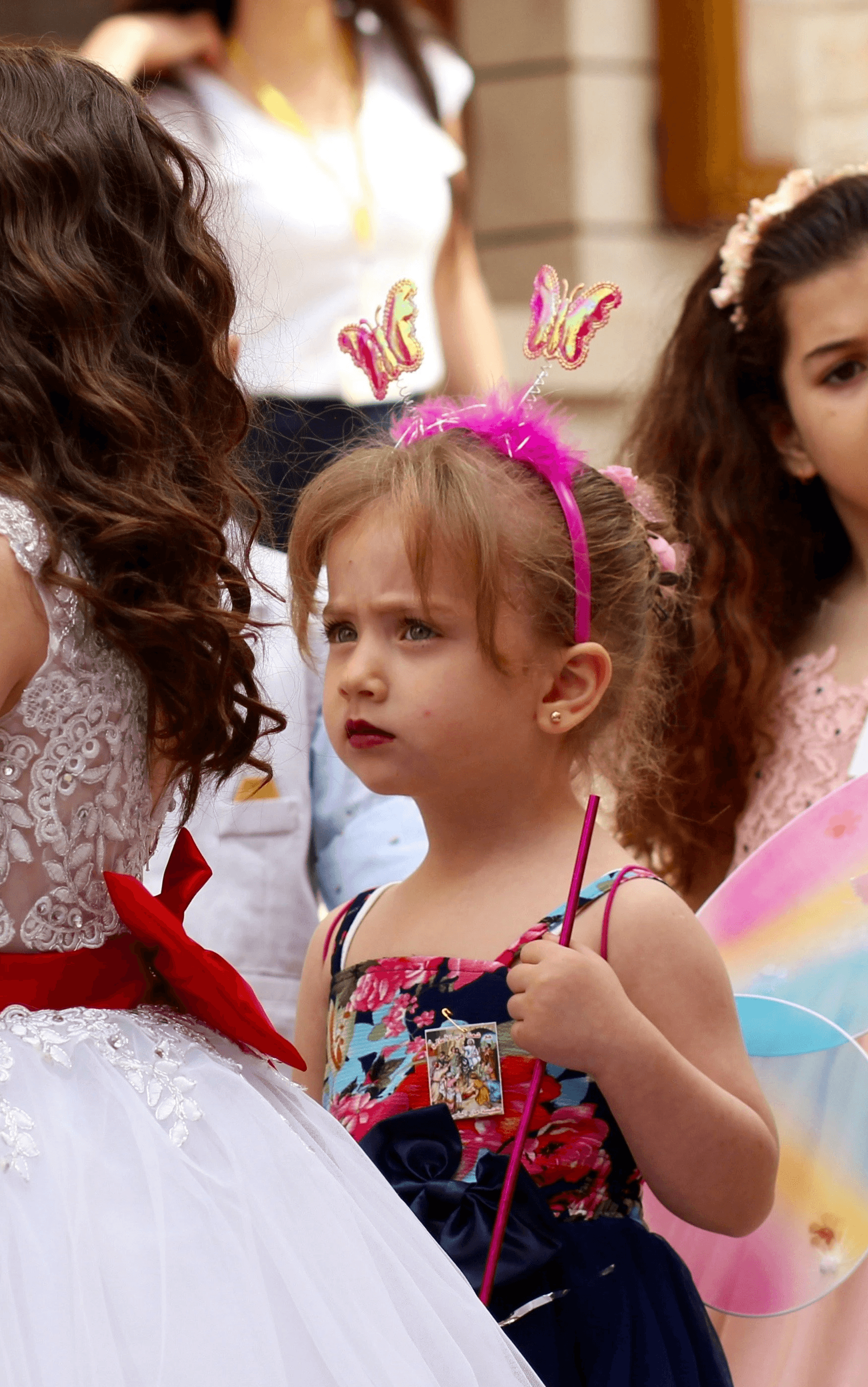woman in white dress holding girl in white dress