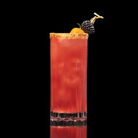 A closeup of a Blackberry Bridge drink against a dark background.