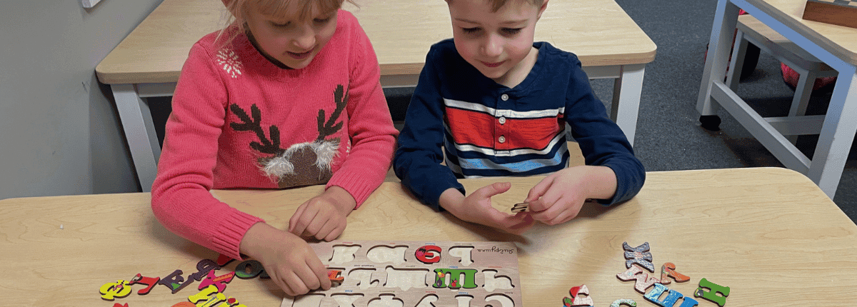 Two kids solving a language puzzle during an educational session at the preschool