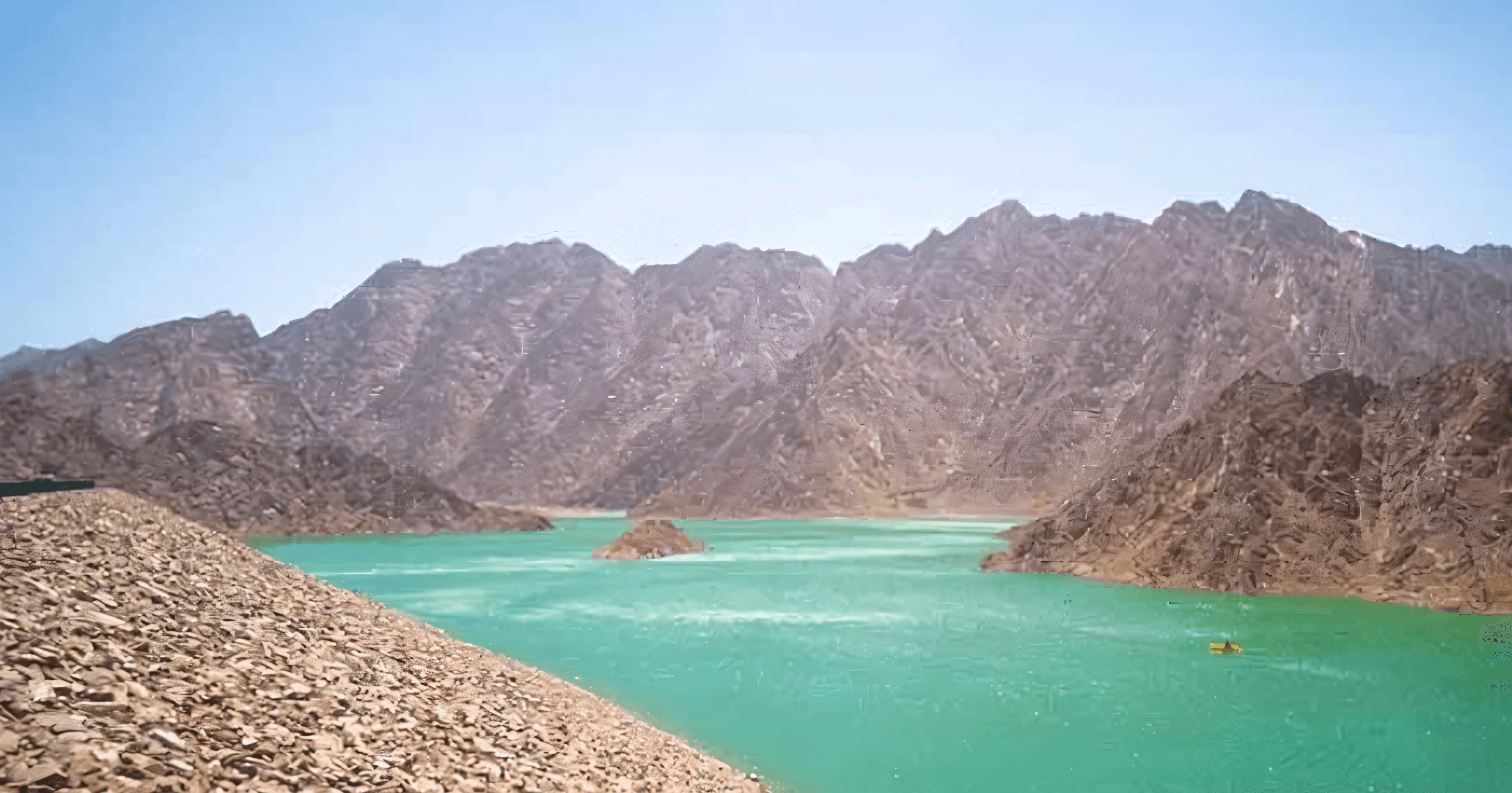 A bus with Arabic writing, including the word "Hatta," drives along a road surrounded by greenery.