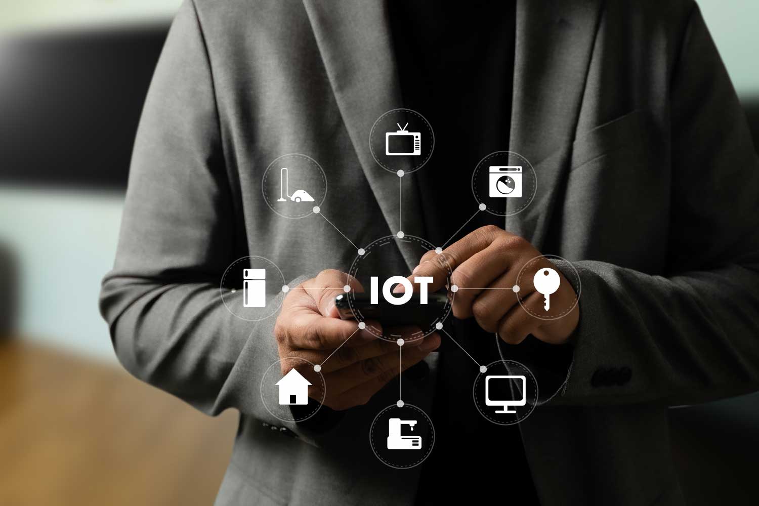 Profissional segurando smartphone com diagrama de Internet das Coisas (IoT) conectando dispositivos como TV, geladeira, casa inteligente e monitor - FindUP - Dispositivos IoT